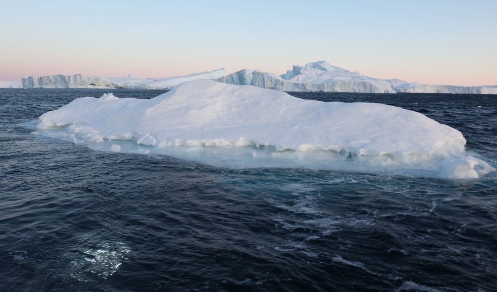 Iceberg at the icefjord at Ilulissat. The lights in the water in the left bottom of the picture is the ROV.